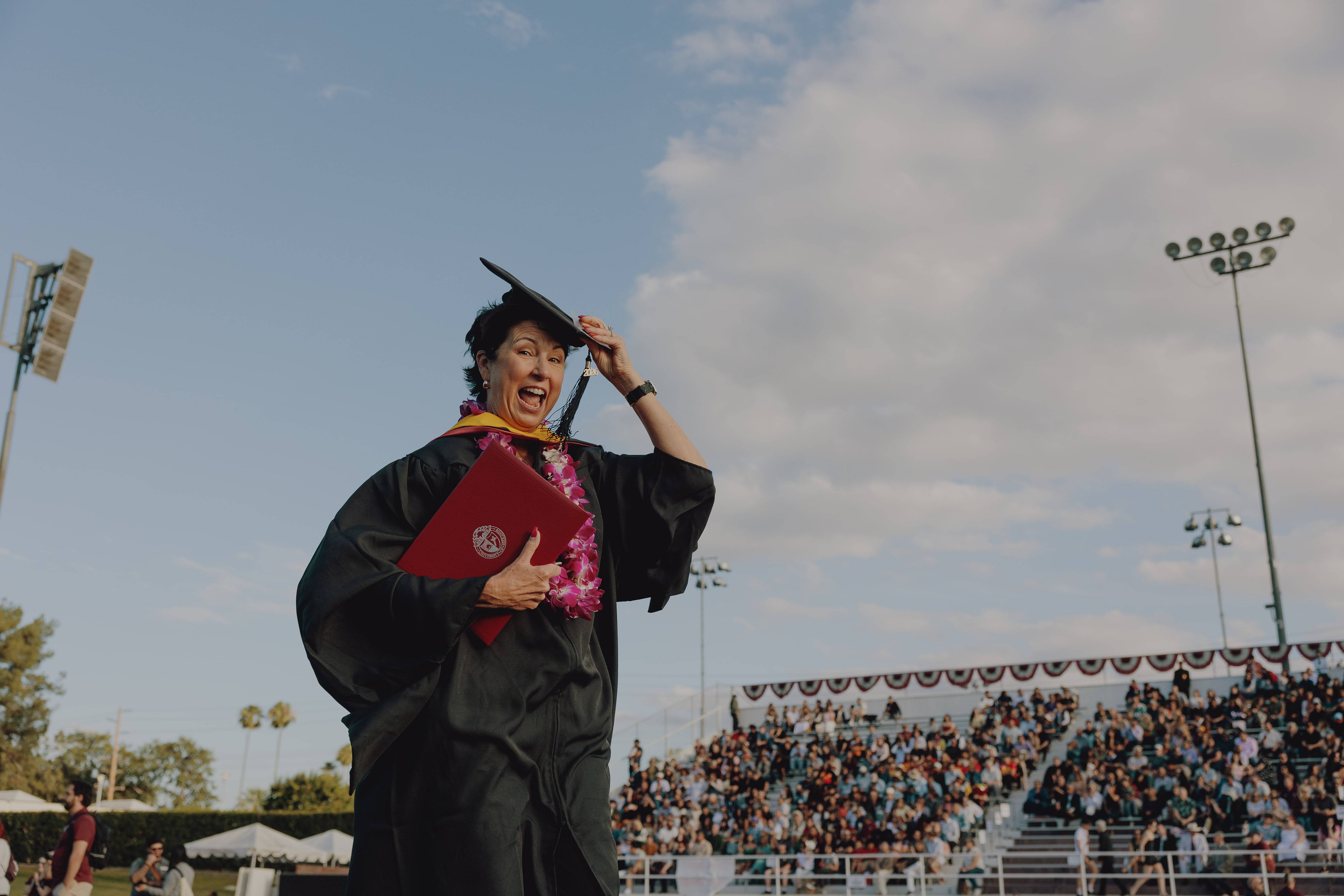 a person in a graduation gown holding a diploma