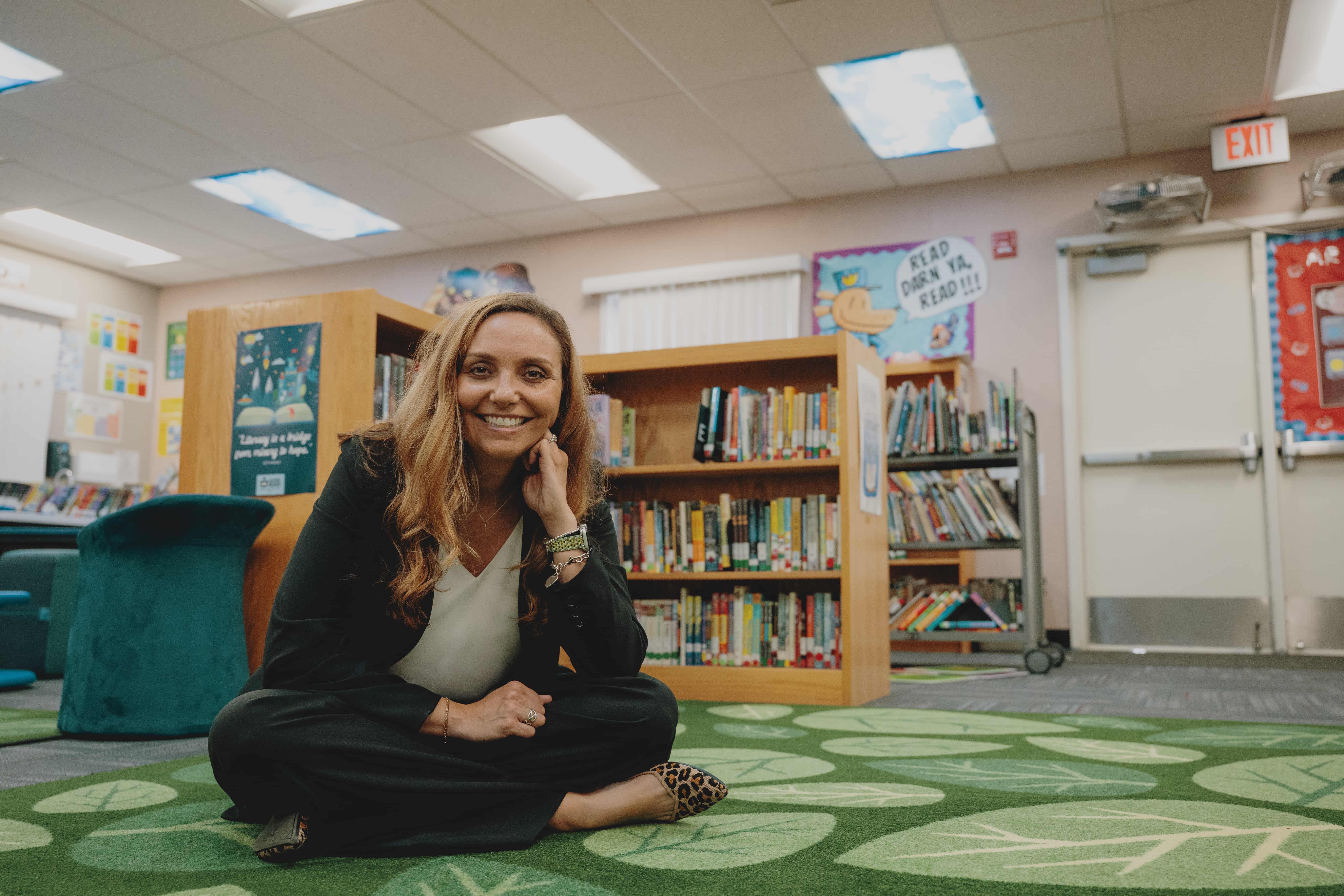 a person sitting on the floor in a library